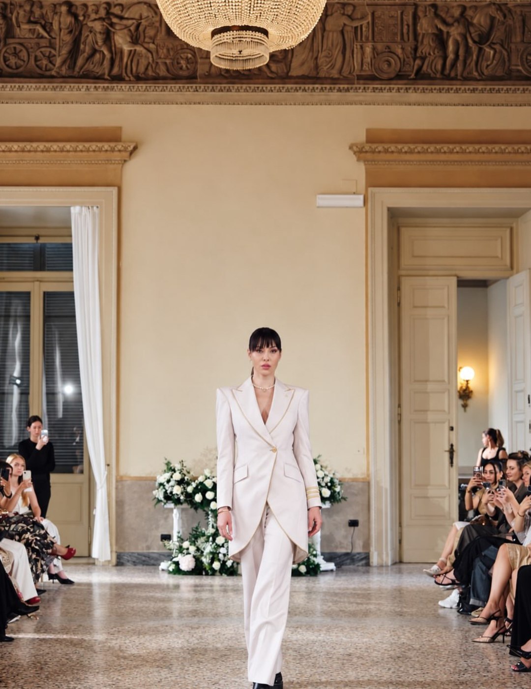 Ivory tailcoat suit with gold piping and a pearl choker
