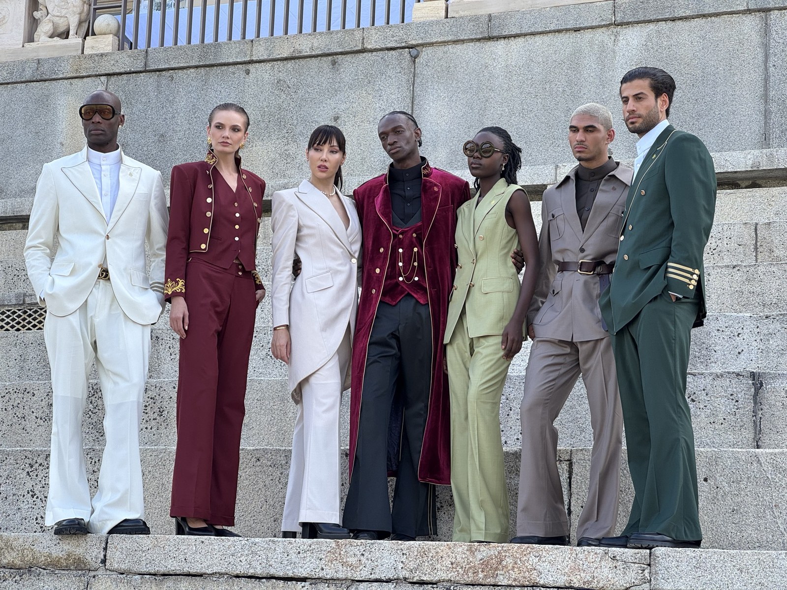 Seven models in the DCASSO collection lined up on stone steps
