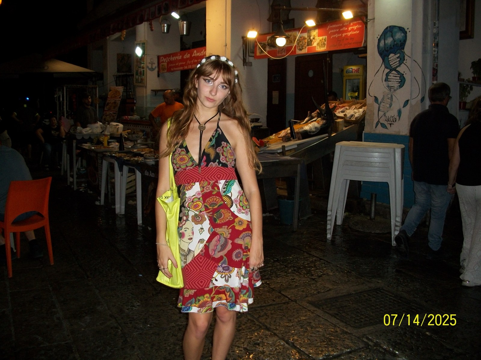 Isabella in a patchwork halter dress, bolo tie and flower crown at a Palermo market at night